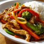 A plate of delicious Easy Chicken Stir Fry with Colorful Veggies, featuring tender chicken strips, broccoli, bell peppers, and snap peas served with rice.
