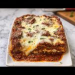A slice of Easy Weeknight Lasagna Bake with melted mozzarella cheese and rich meat sauce.