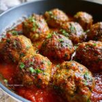 Close-up of juicy turkey meatballs simmered in a rich tomato sauce, garnished with fresh parsley.
