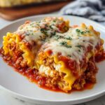 Close-up of two Lasagna Roll Ups with Saucy Comfort, topped with melted cheese and parsley.