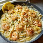 A close-up of Shrimp Alfredo with Creamy Parmesan Sauce, featuring tender shrimp and fettuccine pasta in a rich sauce.