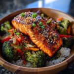 A delicious bowl of Teriyaki Salmon Bowls with Fresh Crunch, featuring a glazed salmon fillet over rice and vibrant vegetables.