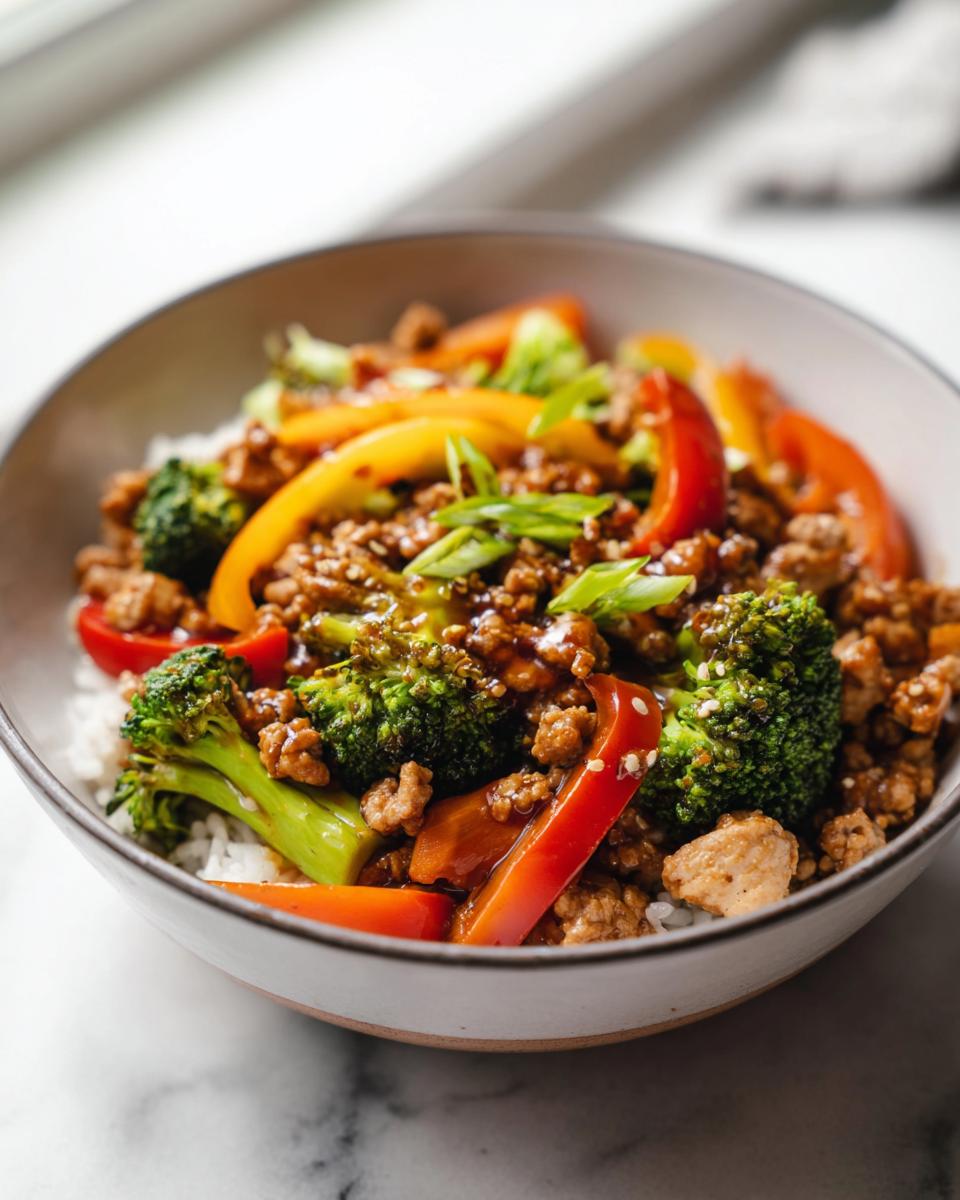 A bowl of Turkey Stir Fry with Sweet and Savory Sauce, featuring ground turkey, broccoli, bell peppers, and rice.