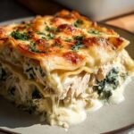 A generous slice of White Chicken Lasagna with creamy cheese layers and shredded chicken, topped with fresh parsley.