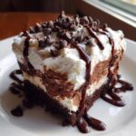 A decadent slice of Easy Chocolate Lasagna Recipe, topped with whipped cream, chocolate chips, and chocolate syrup.